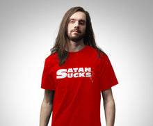 Load image into Gallery viewer, A man with long brown hair and a beard wearing a bright red t-shirt with the text 'SATAN SUCKS' printed in white across the chest, set against a plain light gray background.
